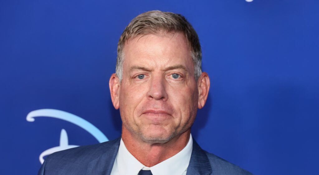 Troy Aikman posing in gray suit
