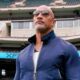 The Rock in sunglasses with XFL logo behind him inside stadium
