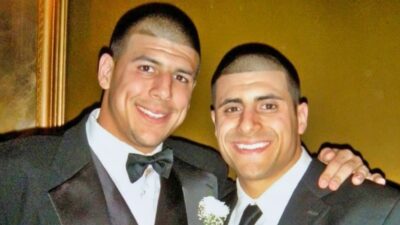 Aaron Hernandez and brother with suits on posing
