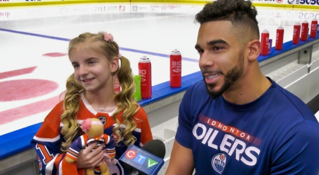 Evander kane and small child holding interview