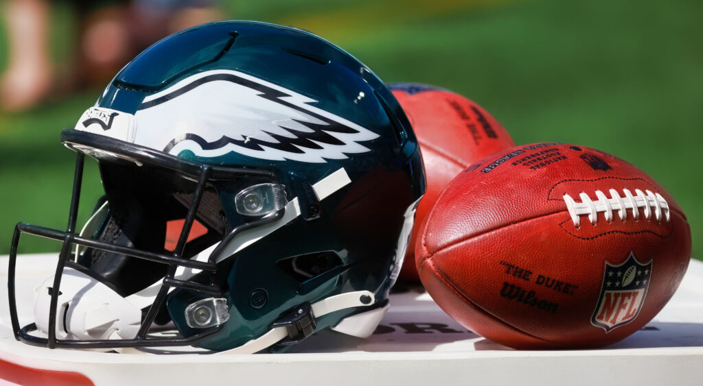 Eagles helmet next to two footballs