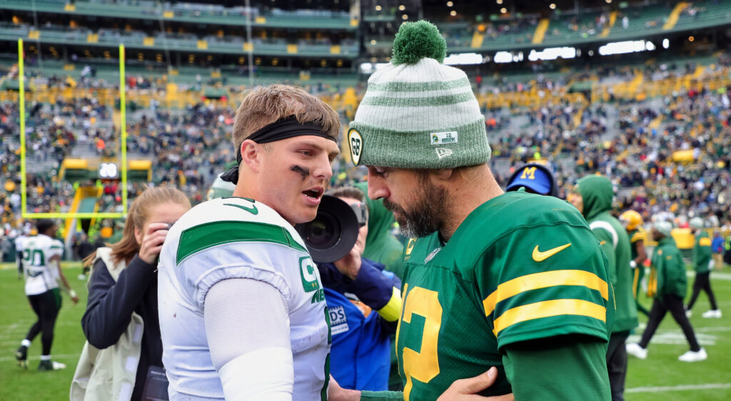 Zach Wilson and Aaron Rodgers embrace each other