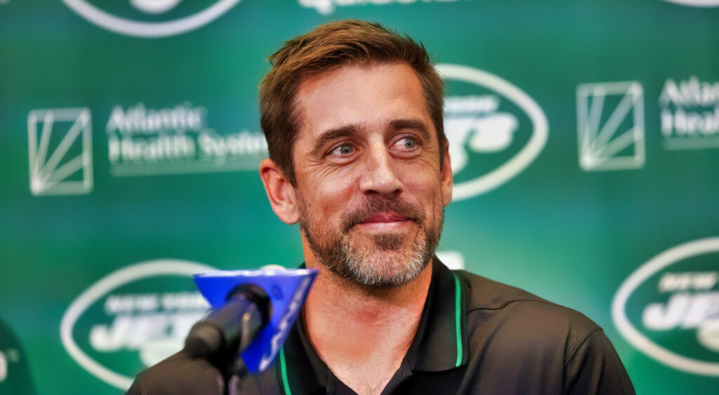 New York Jets quarterback Aaron Rodgers looks on at press conference.