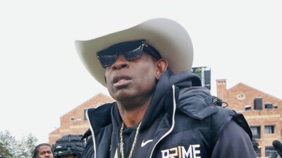 Deion Sanders wearing a cowboy hat and sunglasses
