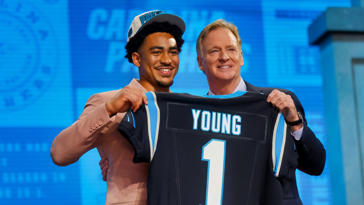 Bryce Young holding jersey with Roger Goodell
