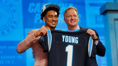 Bryce Young holding jersey with Roger Goodell