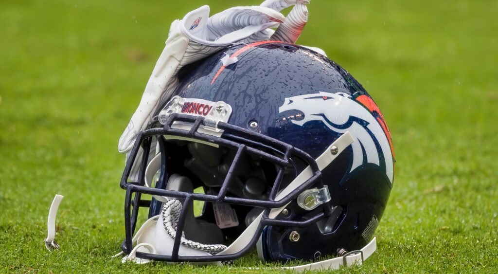 Denver Broncos helmet with rain on it.