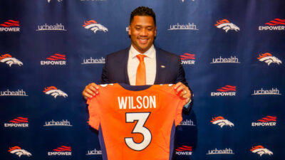 Russell Wilson holding up his Broncos jersey