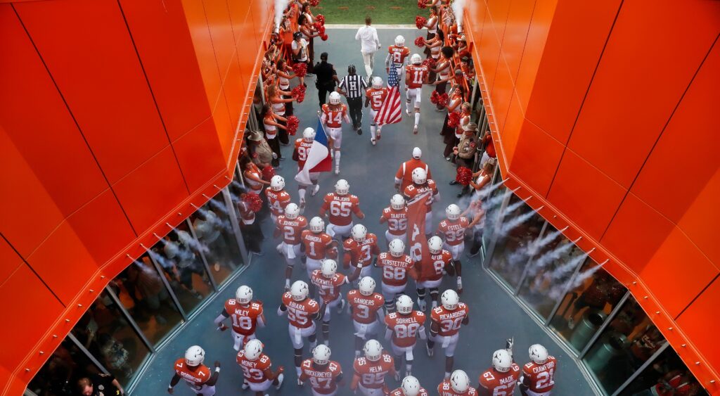 The Texas Longhorns football team takes the field before a game.