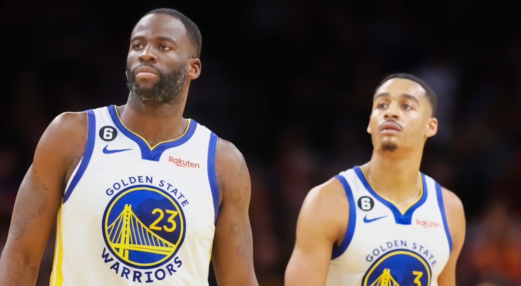 Draymond Green (left) and Jordan Poole (right) of Golden State Warriors walking to bench.