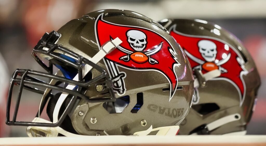 Tampa Bay Buccaneers helmets on a table on the sideline.