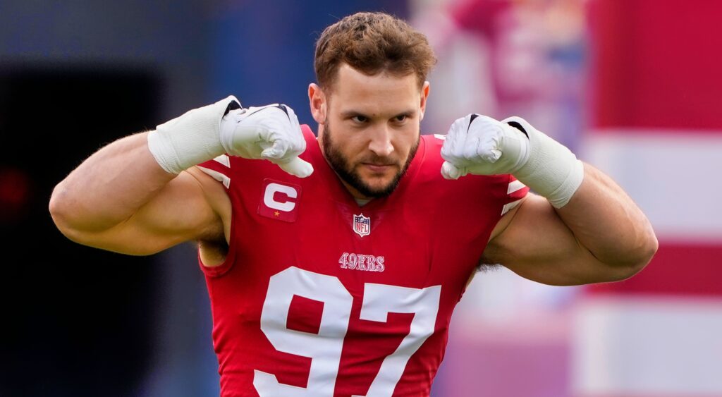 Nick Bosa flexing muscles while in uniform