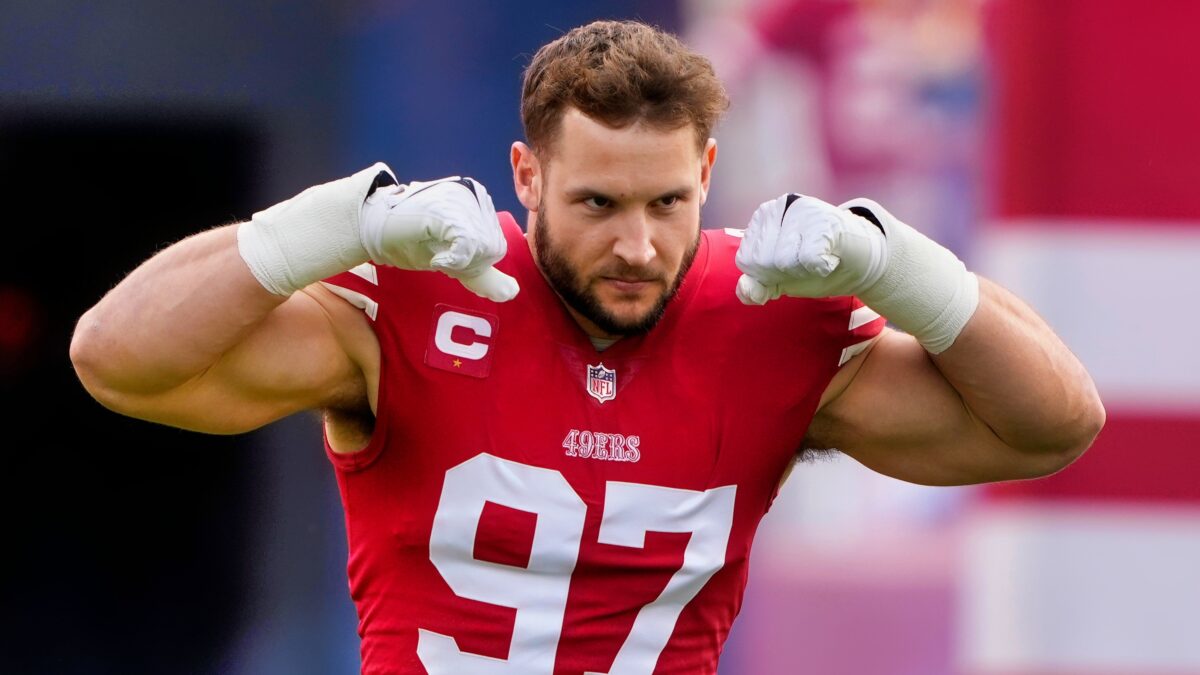 Nick Bosa flexing muscles while in uniform