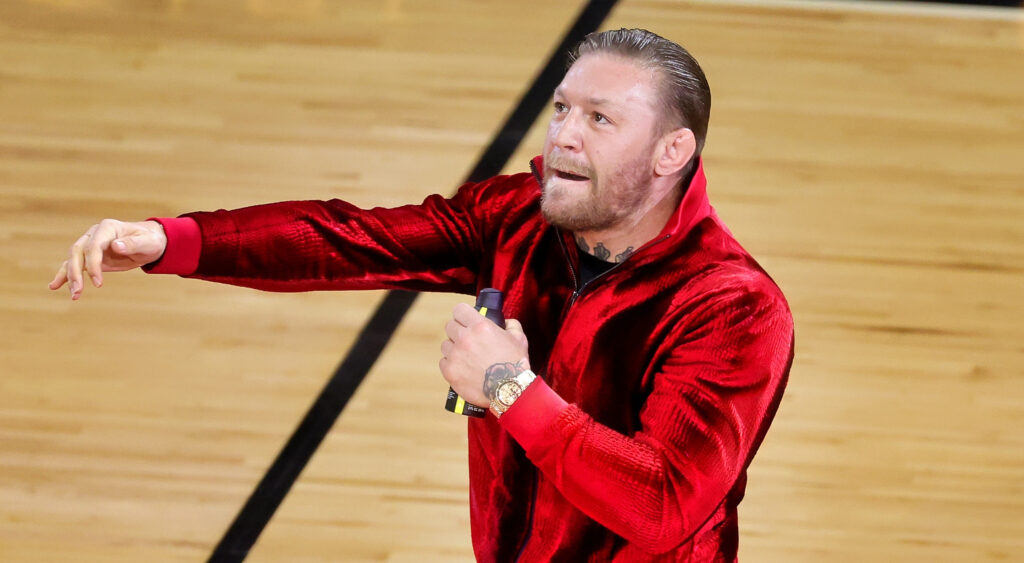 Conot McGregor holding mic in red outfit