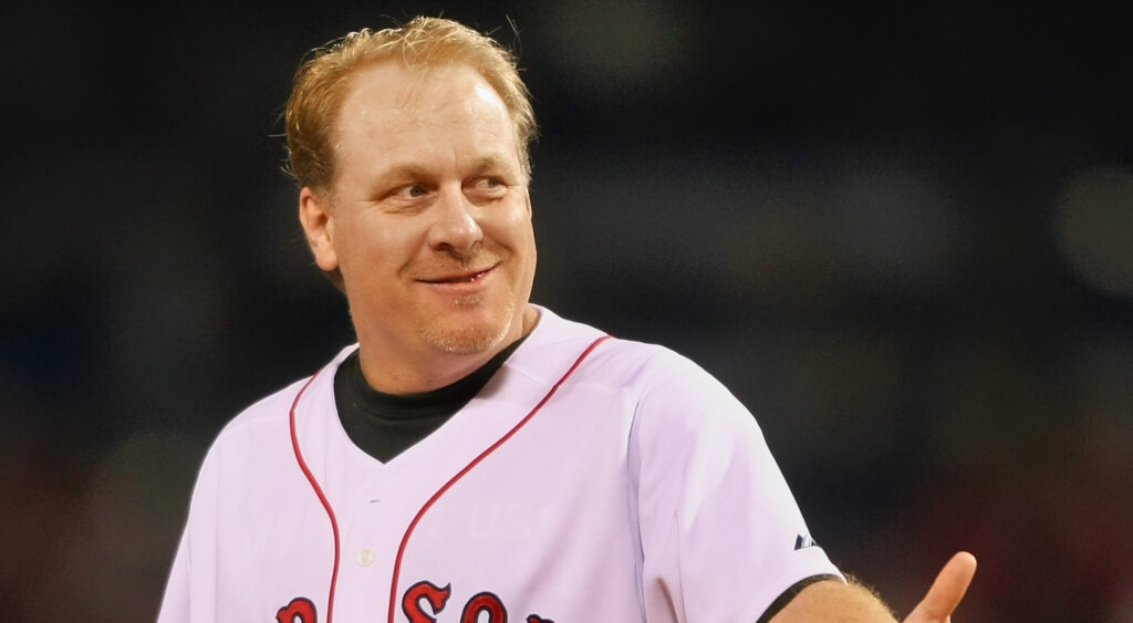 Curt Schilling smiling in red sox jersey.