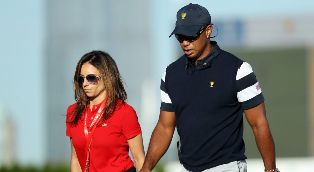 Tiger Woods and Erica Herman walk on the golf course during the President's Cup.