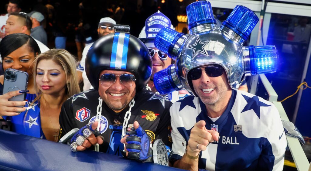 Dallas Cowboys fans with funny helmets watch the game.