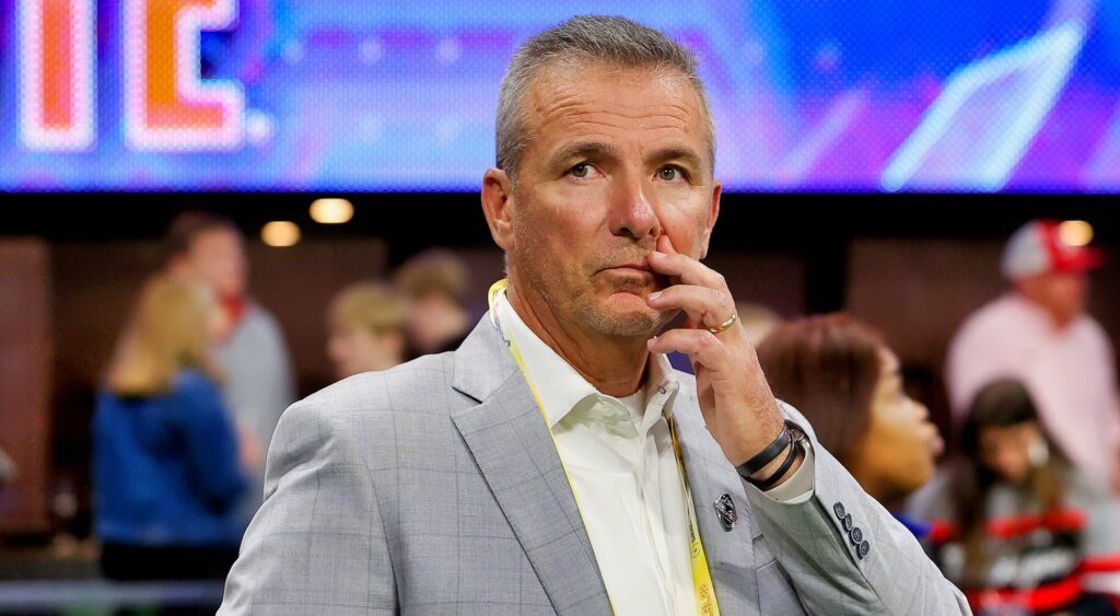 Urban Meyer in suit touching his face