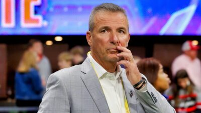 Urban Meyer in suit touching his face