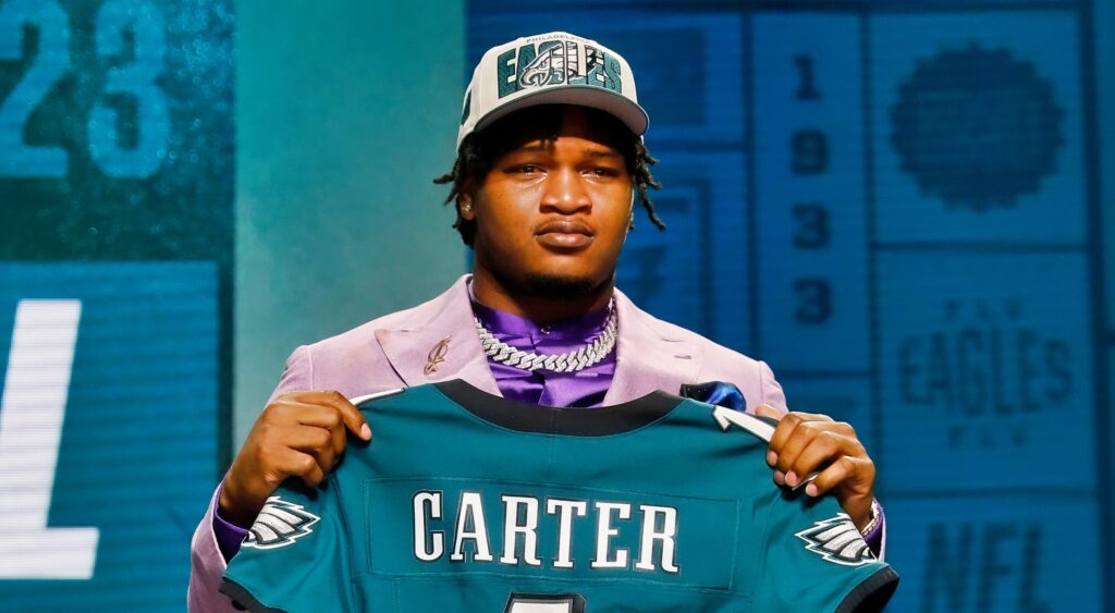 Jalen Carter holds up his jersey after being drafted by the Eagles.