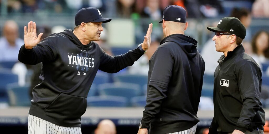 New York Yankees' manager Aaron Boone reacts with hands up during game.