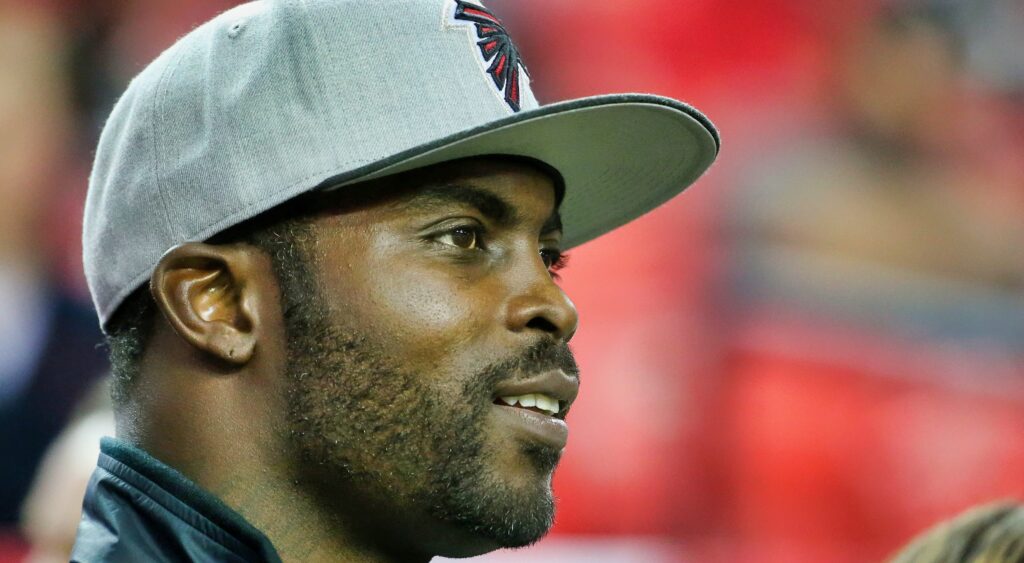 Michael Vick looks on with a cap on.