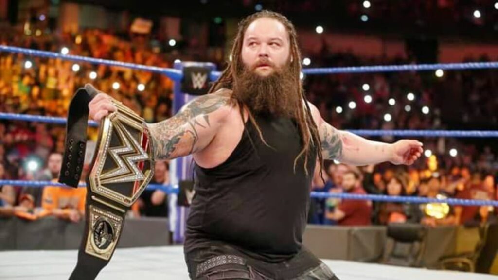 Bray Wyatt holds the WWE title while on his knees in the ring.