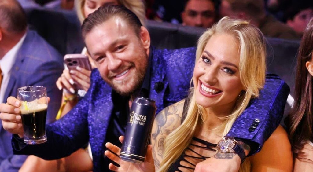 Conor McGregor and Ebanie Bridges pose for a photo at a boxing match.