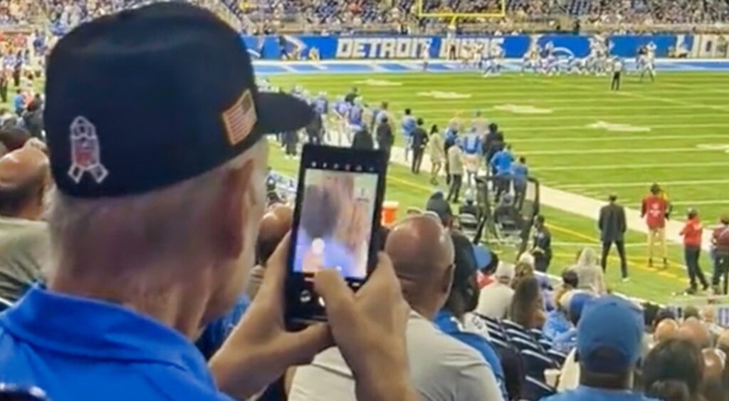 Screenshot of a Lions fan filming a cheerleader.