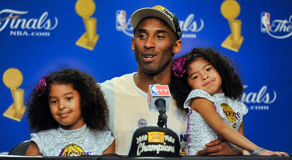 Kobe Bryant speaking to reporters with his two daughters