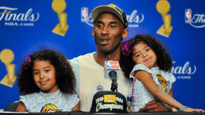 Kobe Bryant speaking to reporters with his two daughters