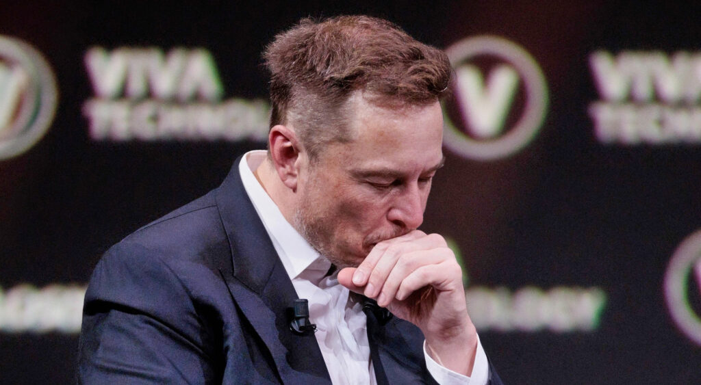 Elon Musk with a hand on his mouth