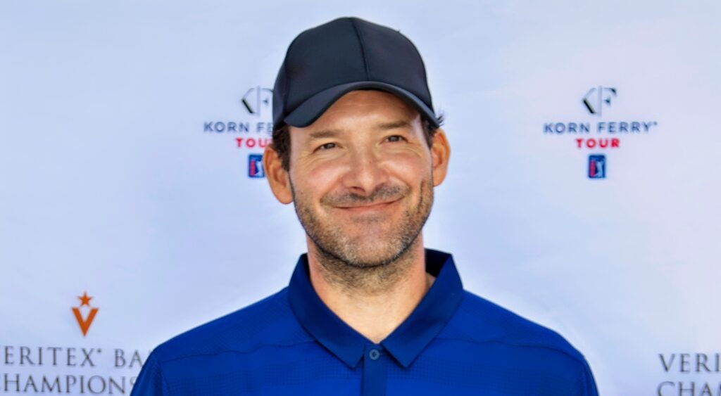 Tony Romo smiles while speaking to reporters at a golf tournament.