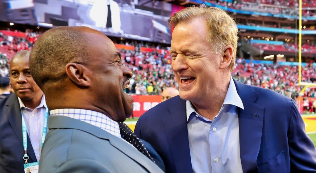 Roger Goodell and DeMaurice Smith laugh on the field.