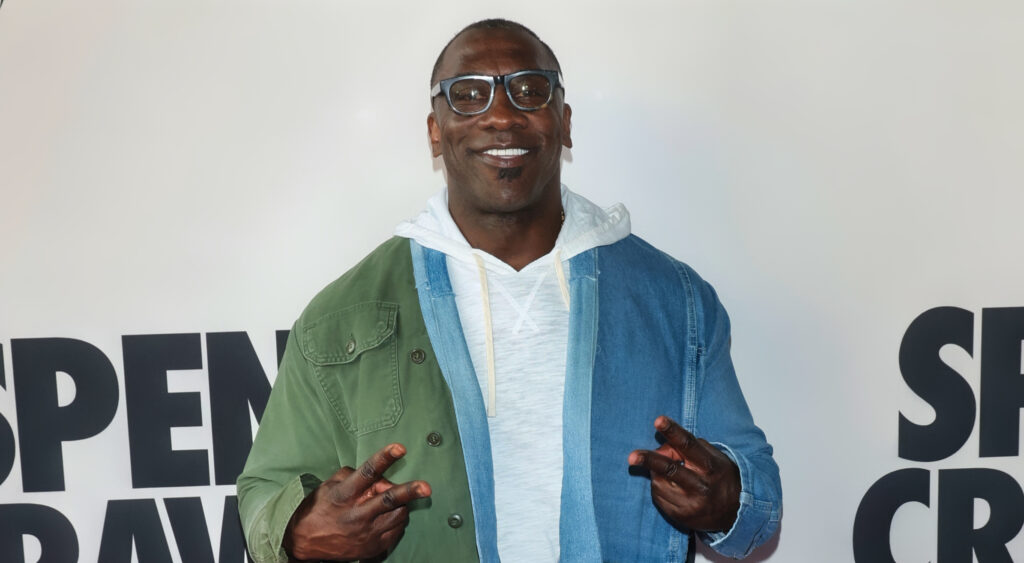 Shannon Sharpe holding two fingers up on each hand