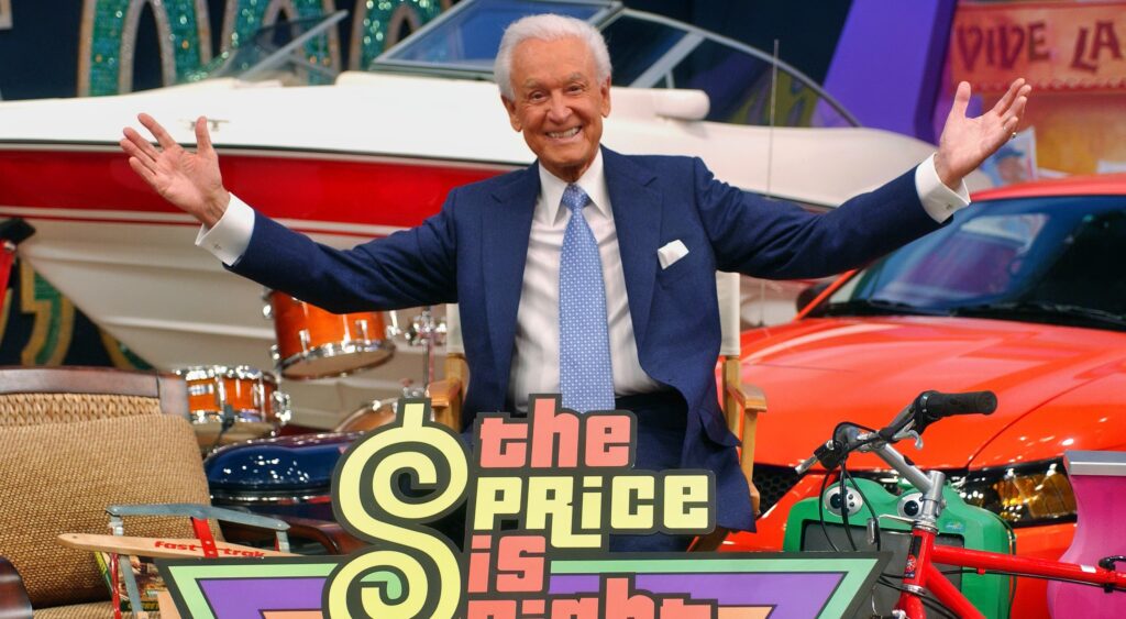 Bob Barker holds out his arms on the Price Is Right set.