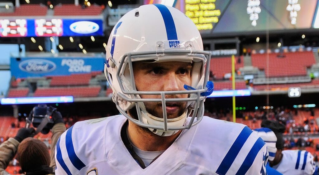 Andrew Luck walks off the field with his helmet on.