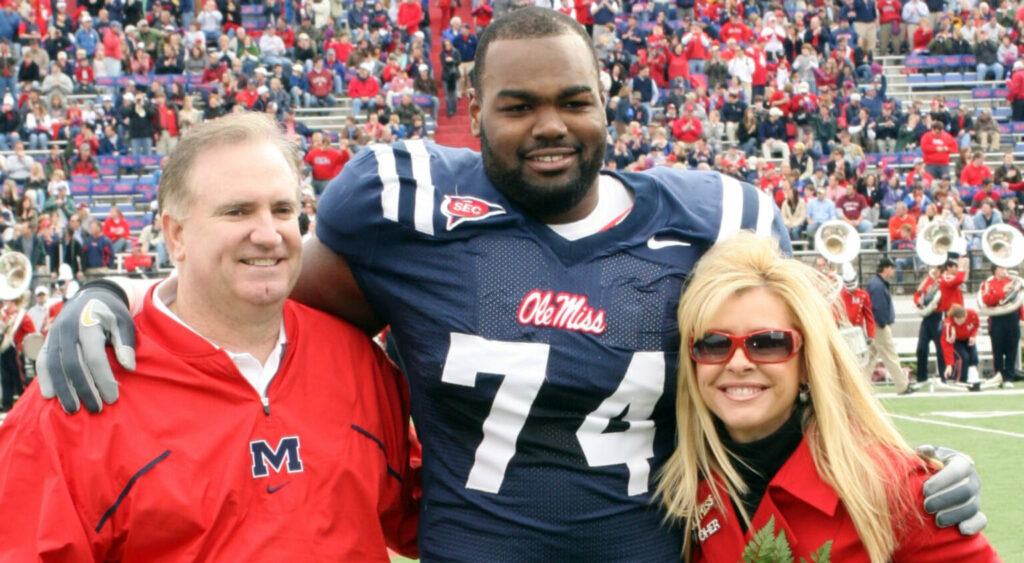 Sean Tuohy (left), Michael Oher (middle) and Leigh Anne Tuohy (right) on field together.