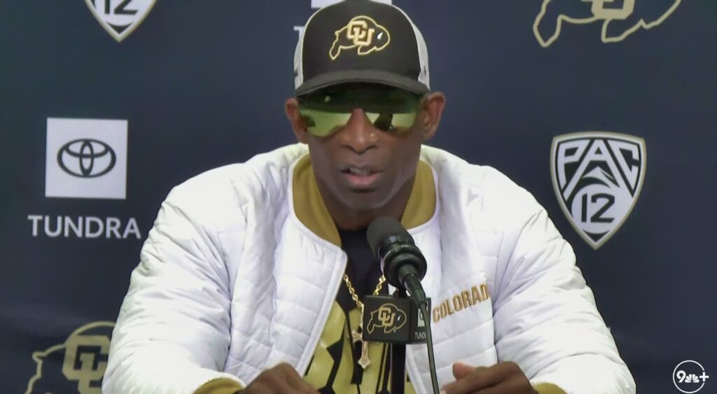 Deion Sanders speaking at a press conference.