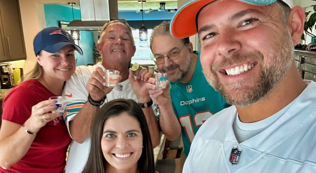 Family of Dolphins Fans hold up their tequila shots.