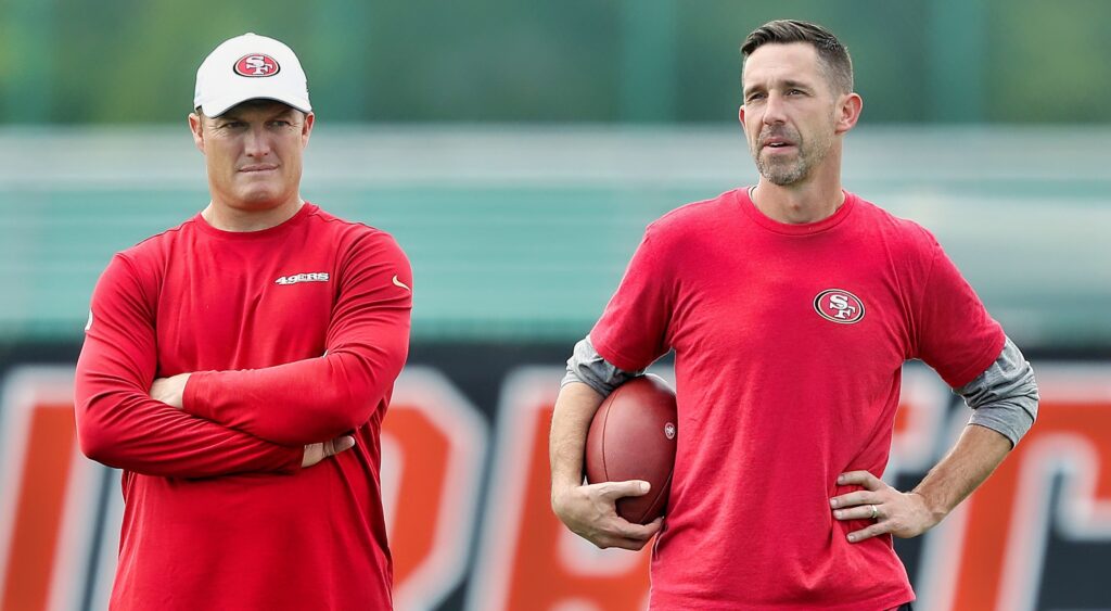 Kyle Shanahan and John Lynch look on during practice.