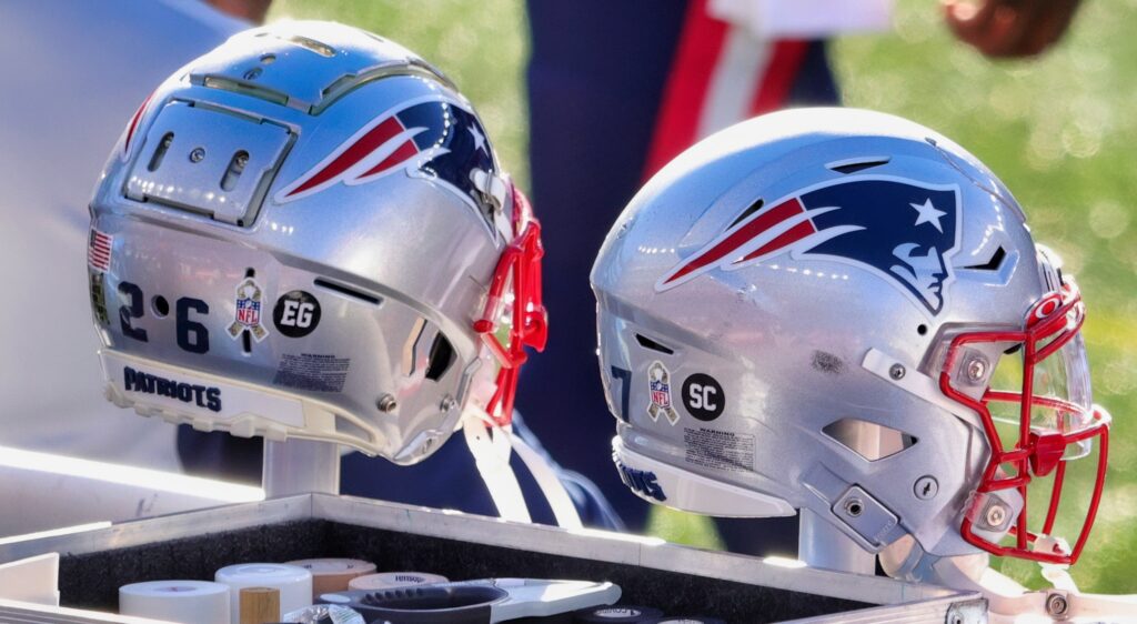 Two Patriots helmets on the bench.