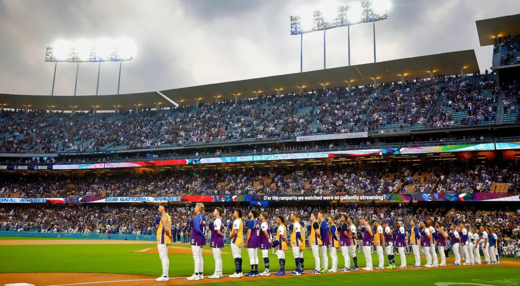 Dodgers players line up along third baseline in Kobe Bryant jerseys.