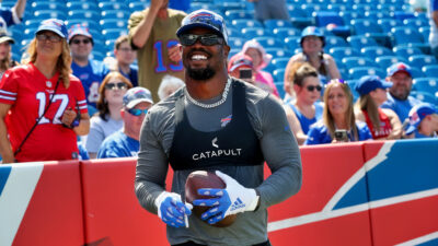 Von Miller smiling and holding a football