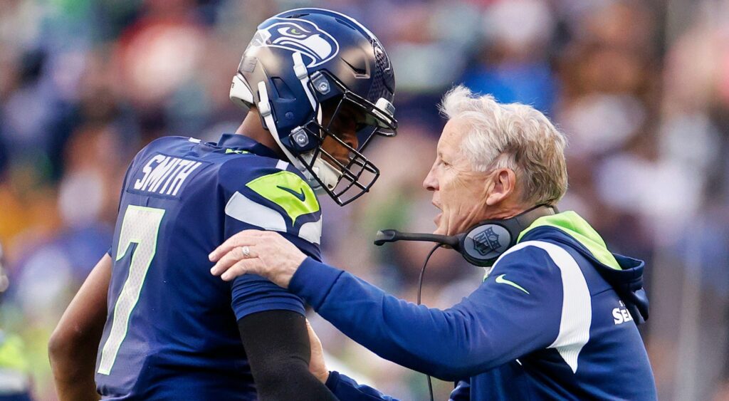 Geno Smith (left) and Pete Carroll (right) talking.