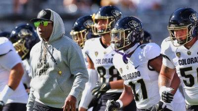 Deion Sanders standing in front oc Colorado players