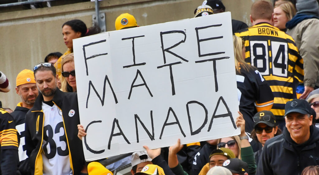 Fans holding up "Fire Matt Canada" sign