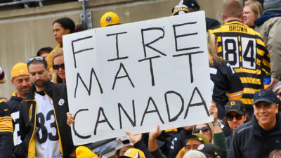 Fans holding up "Fire Matt Canada" sign
