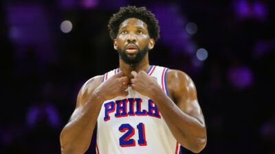 Joel Embiid holding collar of 76ers jersey
