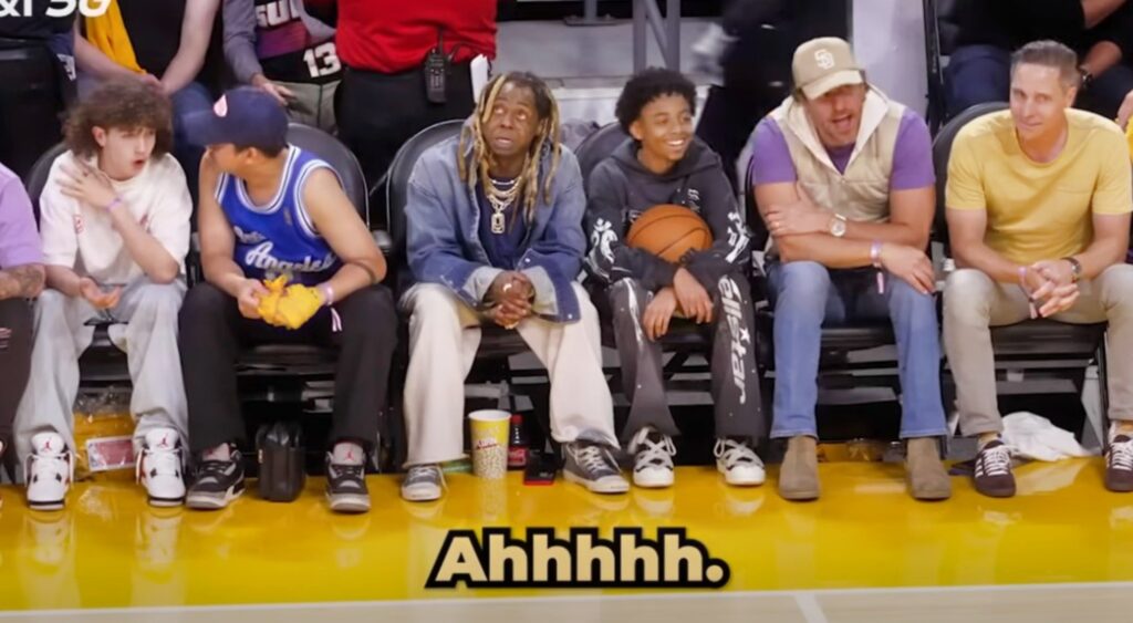 Lil Wayne sitting courtside with son